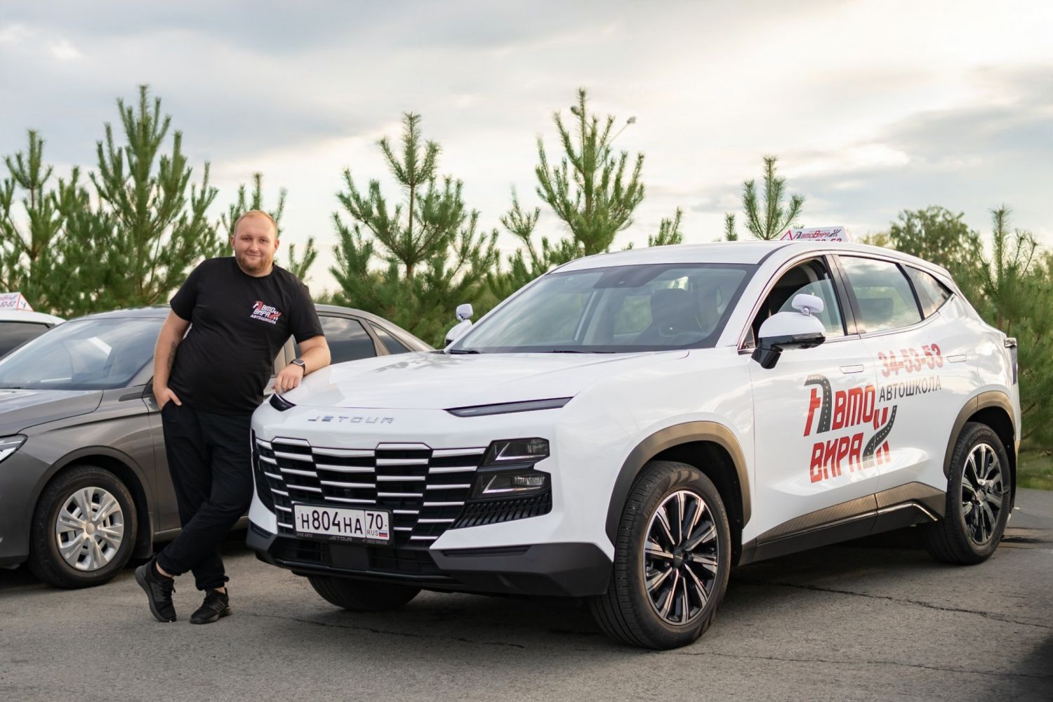 Инструктор у учебных автомобилей Omoda C5 и Chery Tiggo